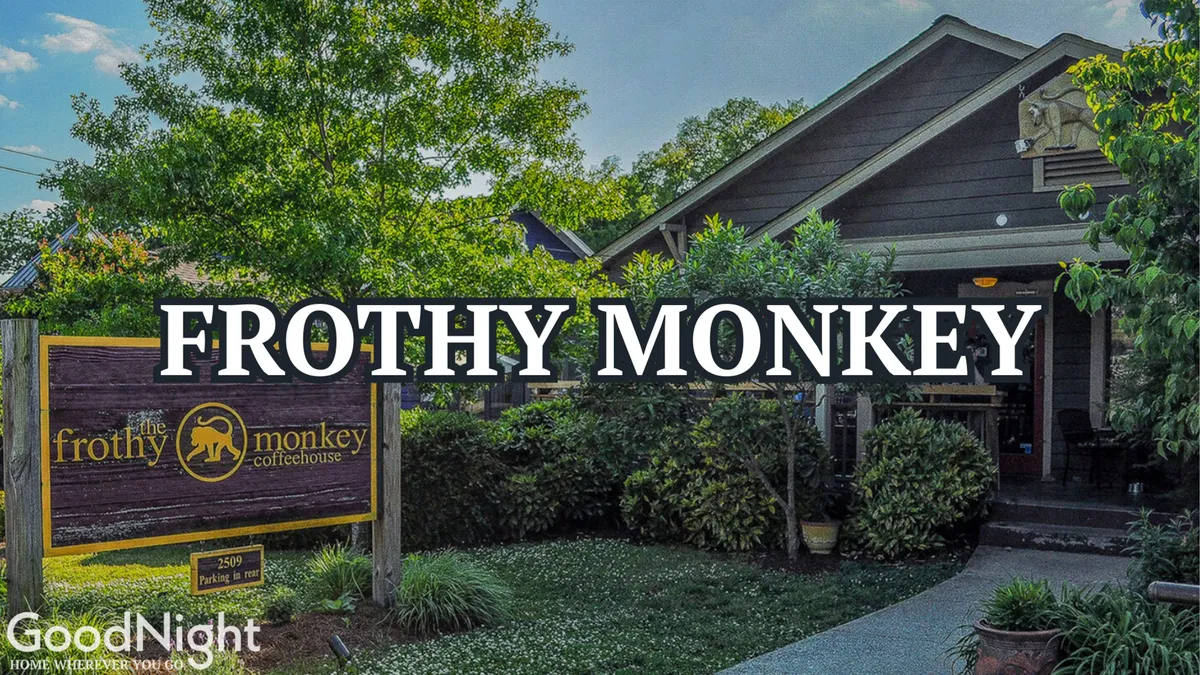 The welcoming entrance to Frothy Monkey coffeehouse, surrounded by greenery, with guests enjoying coffee and socializing outdoors. The inviting setting exudes a cozy, local vibe perfect for relaxed meals or casual drinks.
