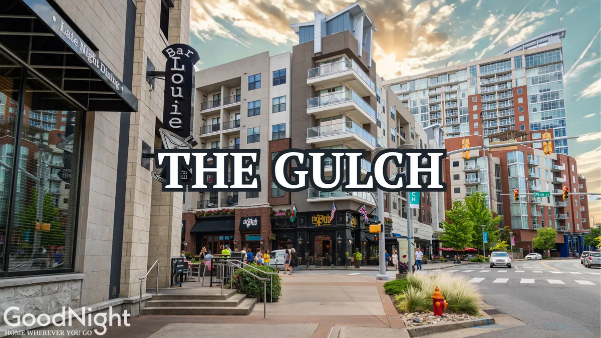 An exterior shot of The Gulch with Bar Louie and nearby restaurants, bustling with pedestrian activity. The signage and outdoor patios highlight the area's diverse dining options and lively social vibe, suggesting ease of access to renowned food destinations.